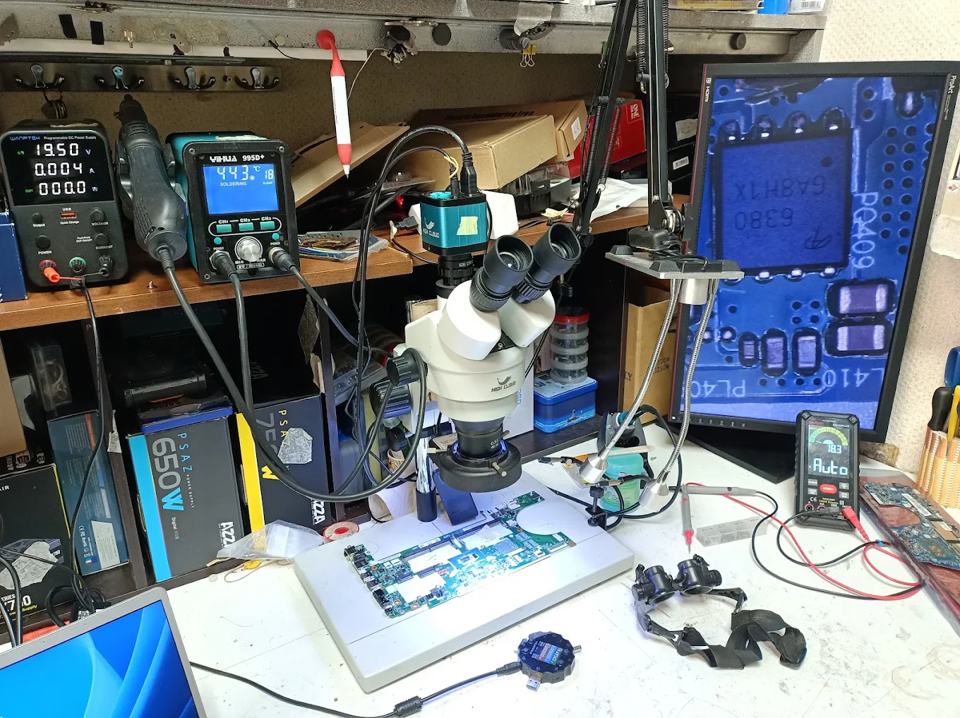 Plan de travail d'atelier avec microscope, station de soudure et outils de réparation électronique